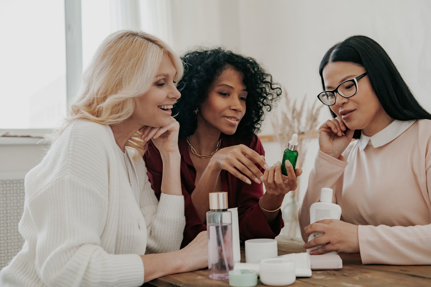 Three women examining beauty products together